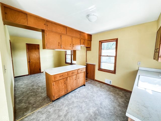 kitchen with kitchen peninsula, sink, and light colored carpet