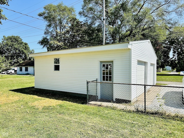 view of property exterior with an outdoor structure, a yard, fence, and a garage