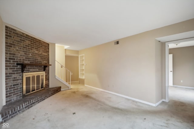 unfurnished living room with carpet flooring and a brick fireplace