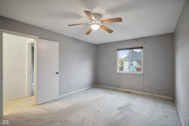 carpeted spare room featuring ceiling fan