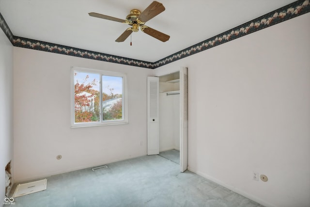 unfurnished room with ceiling fan and light carpet