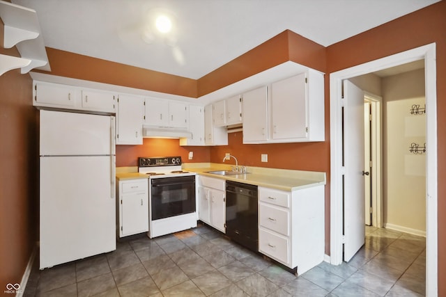 kitchen featuring dark tile patterned flooring, white cabinets, sink, and white appliances