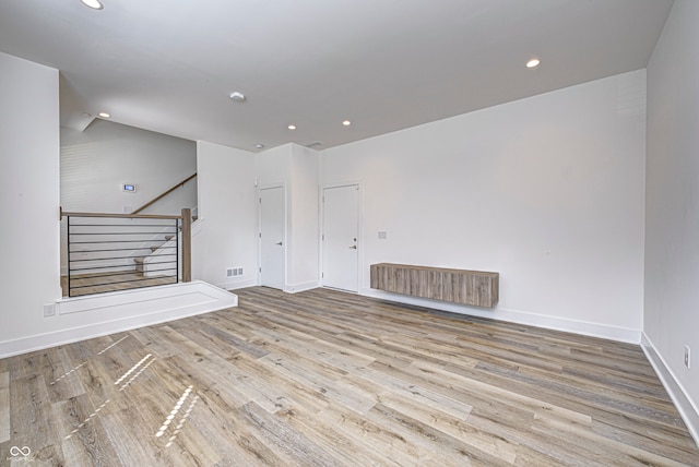 unfurnished living room featuring light wood-type flooring and vaulted ceiling