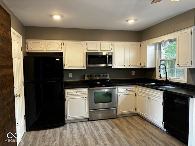 kitchen featuring black appliances, sink, wood-type flooring, and white cabinets