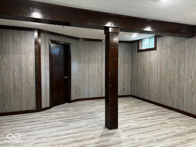 basement featuring wood walls and light hardwood / wood-style floors