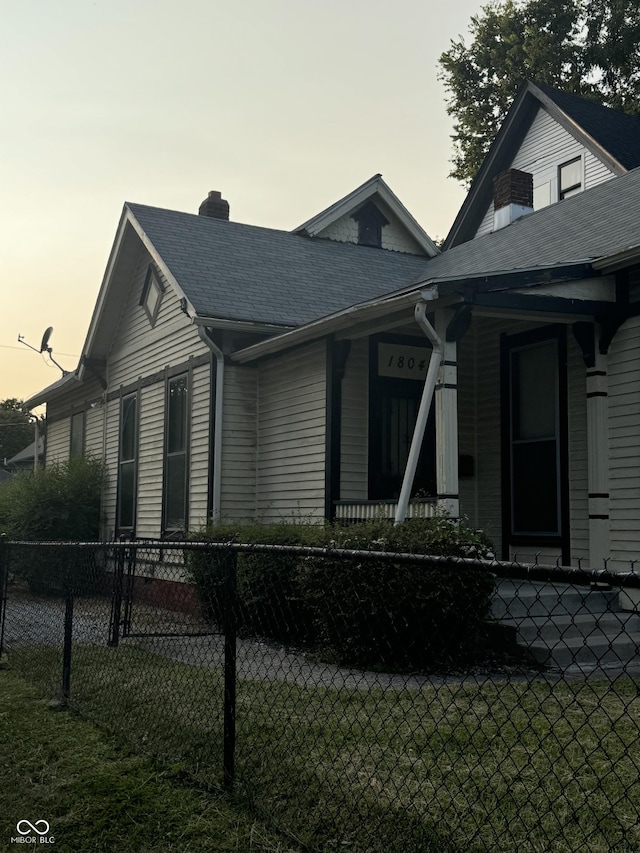 1804 N Delaware St, Indianapolis, IN 46202 - view of front of home with fence, a chimney, roof with shingles, and a porch