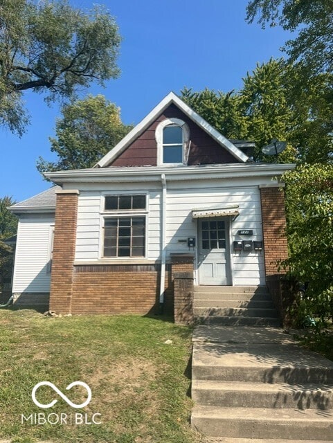 view of front of home with brick siding and a front yard