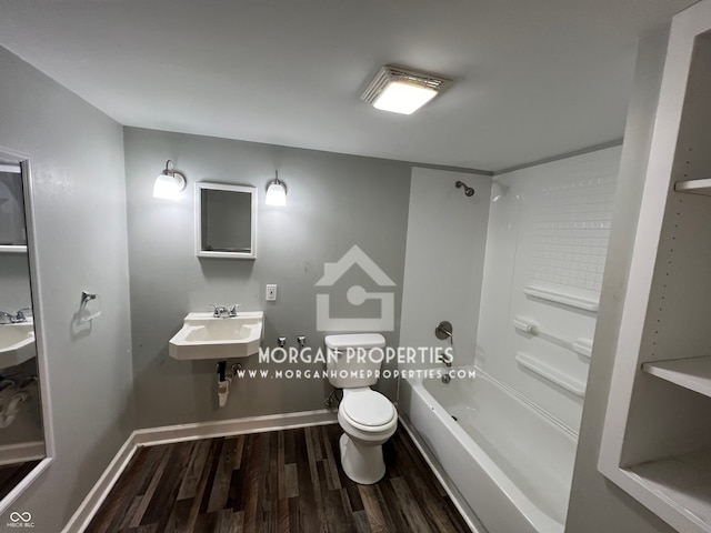 full bathroom with toilet, hardwood / wood-style flooring, bathing tub / shower combination, and sink