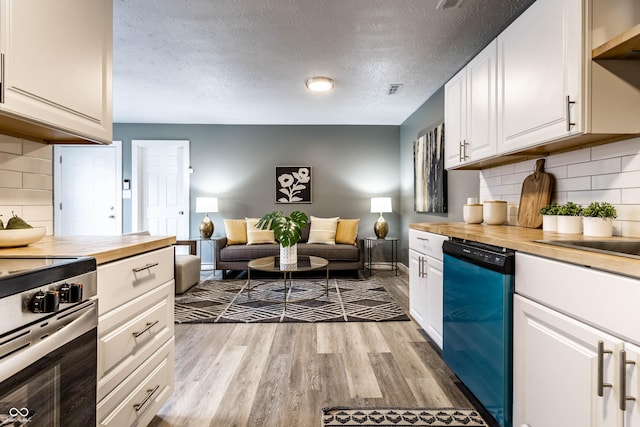 kitchen featuring dishwashing machine, wood counters, white cabinetry, open floor plan, and light wood finished floors