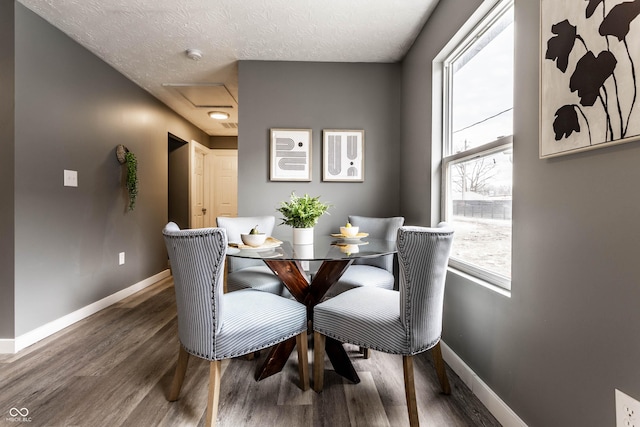 dining space featuring baseboards, wood finished floors, and a healthy amount of sunlight