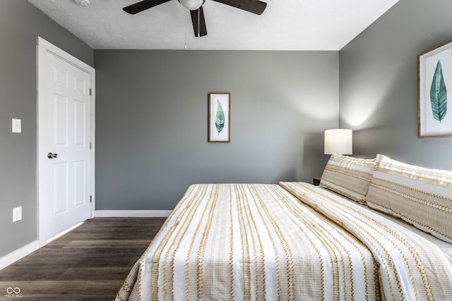 unfurnished bedroom with a textured ceiling, ceiling fan, wood finished floors, and baseboards