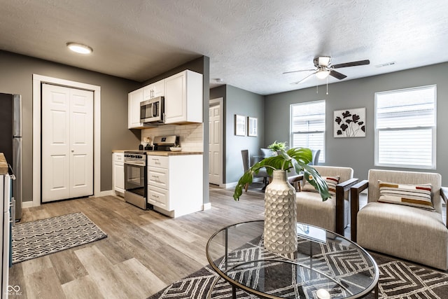 interior space featuring light wood-style flooring, visible vents, and baseboards