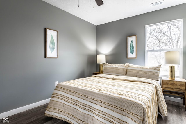 bedroom featuring baseboards, visible vents, ceiling fan, and wood finished floors