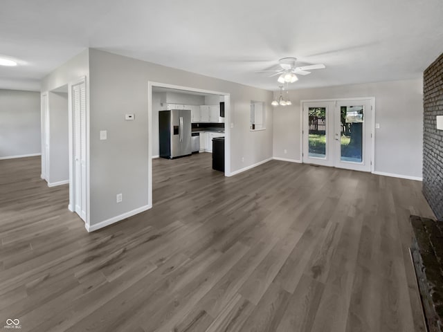 unfurnished living room with dark hardwood / wood-style flooring and ceiling fan