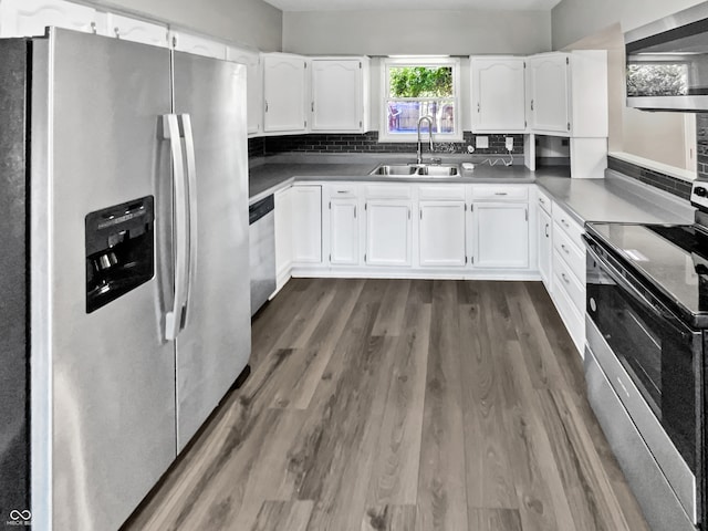 kitchen with dark hardwood / wood-style flooring, tasteful backsplash, stainless steel appliances, sink, and white cabinets