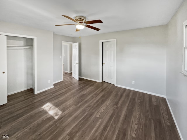 unfurnished bedroom with dark wood-type flooring, ceiling fan, and a closet