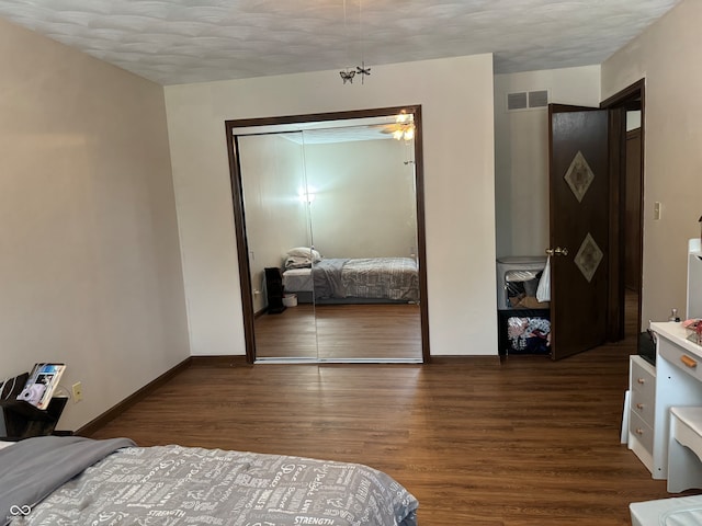 bedroom with a textured ceiling, a notable chandelier, a closet, and dark hardwood / wood-style flooring