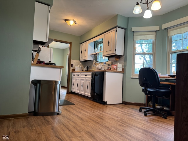 kitchen featuring black dishwasher, light hardwood / wood-style flooring, hanging light fixtures, and white cabinets