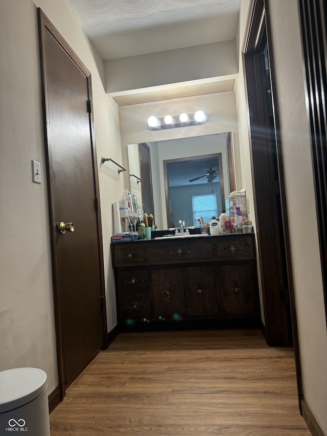 bathroom featuring toilet, wood-type flooring, ceiling fan, and vanity