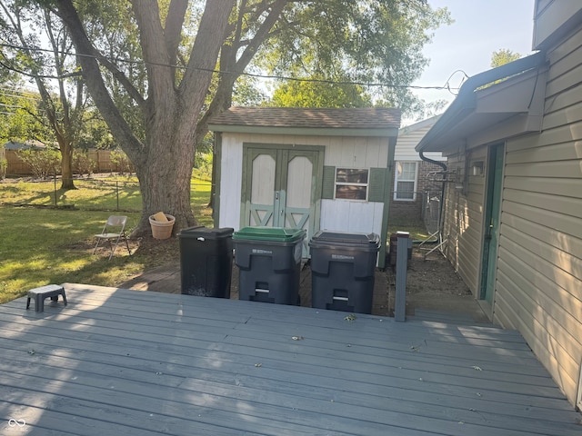 wooden terrace featuring a storage shed and a lawn