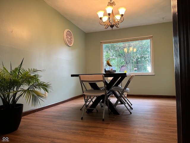 dining room with lofted ceiling, hardwood / wood-style flooring, and a chandelier