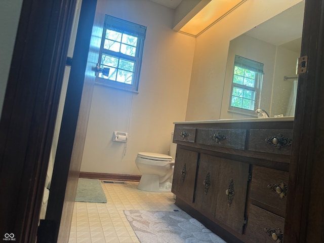 bathroom featuring plenty of natural light, vanity, toilet, and tile patterned floors