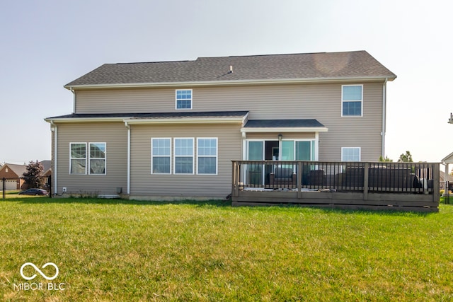 rear view of property featuring a lawn and a deck