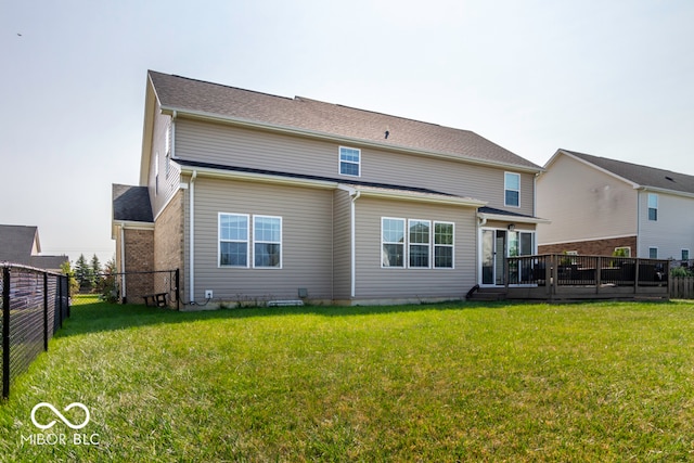 rear view of house with a yard and a wooden deck