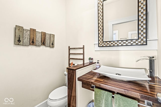 bathroom featuring a sink, baseboards, and toilet