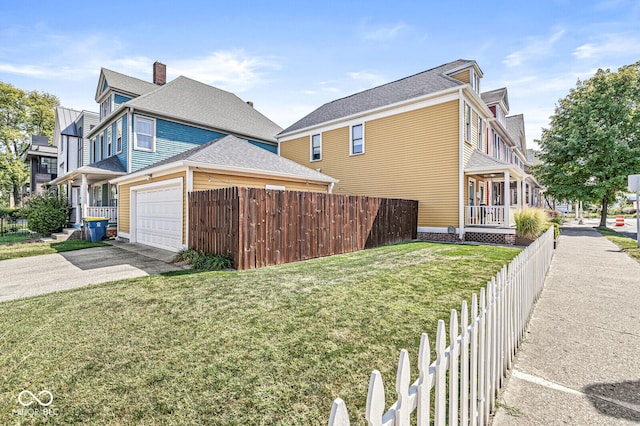 view of home's exterior with an attached garage, fence, a lawn, and driveway