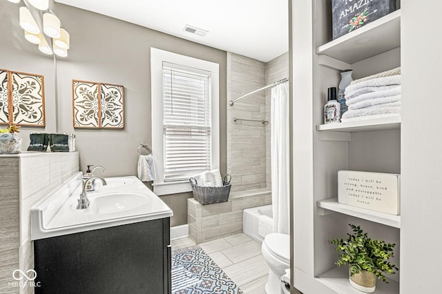 bathroom featuring vanity, baseboards, visible vents, toilet, and shower / tub combo with curtain