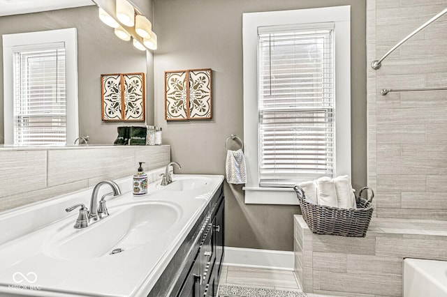 full bath with a washtub, a wealth of natural light, and a sink