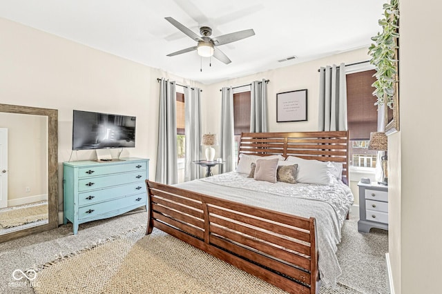 bedroom featuring light carpet, visible vents, baseboards, and a ceiling fan