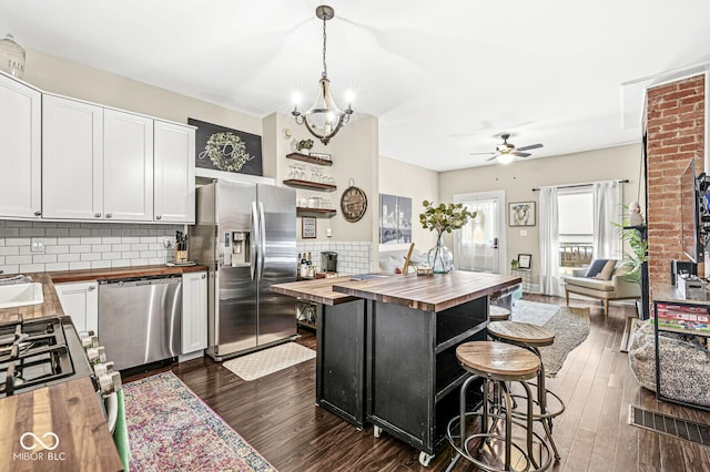 kitchen featuring dark wood finished floors, white cabinets, appliances with stainless steel finishes, and wood counters