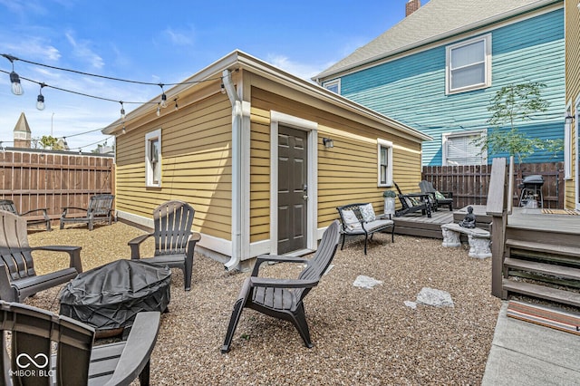 view of patio / terrace featuring a wooden deck, a fenced backyard, and an outdoor fire pit