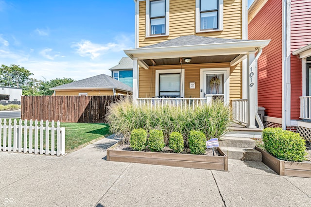 property entrance with a porch and fence