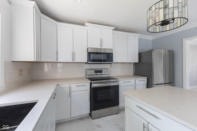 kitchen with ornamental molding, appliances with stainless steel finishes, white cabinetry, and tasteful backsplash