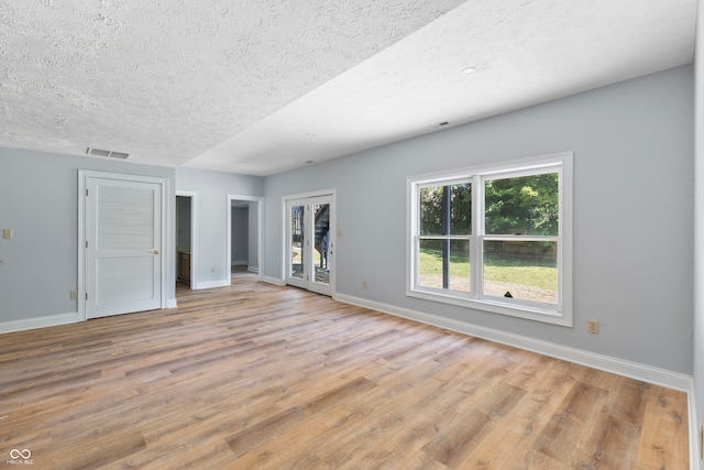 interior space with a textured ceiling and light hardwood / wood-style flooring