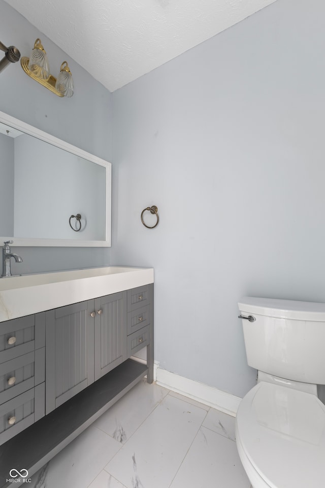 bathroom featuring vanity, toilet, and a textured ceiling