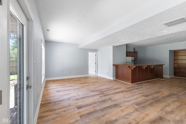 unfurnished living room featuring a textured ceiling and wood-type flooring