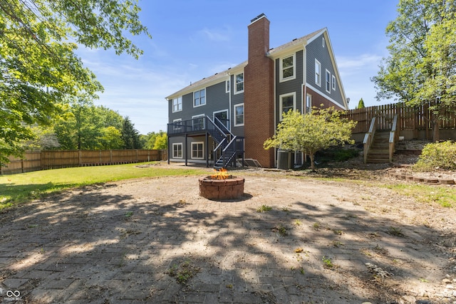 back of property with a wooden deck, an outdoor fire pit, and central air condition unit