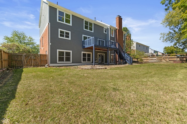 rear view of house with a lawn and a deck