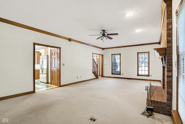 unfurnished living room featuring light carpet, crown molding, a brick fireplace, and ceiling fan