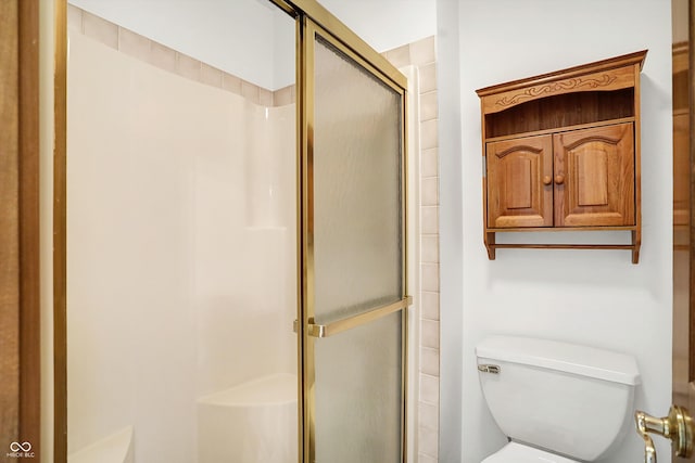 bathroom featuring toilet and an enclosed shower