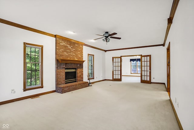 unfurnished living room featuring light colored carpet, ceiling fan, ornamental molding, and a fireplace