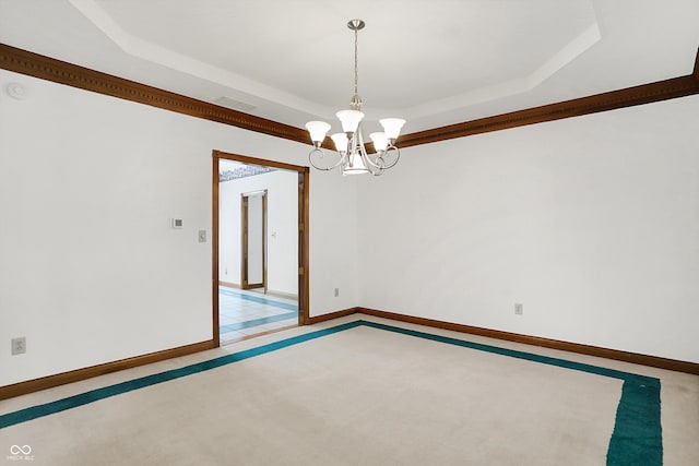 unfurnished room featuring a tray ceiling, light carpet, and an inviting chandelier