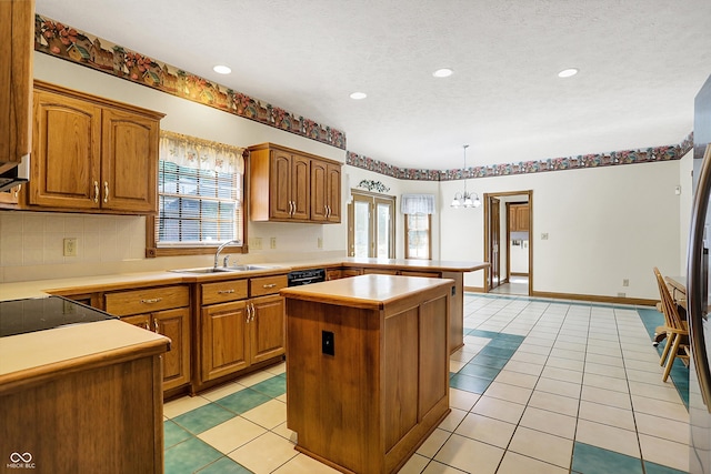 kitchen featuring a textured ceiling, a healthy amount of sunlight, a center island, and hanging light fixtures