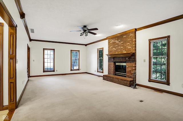 unfurnished living room with ceiling fan, light colored carpet, a fireplace, and crown molding