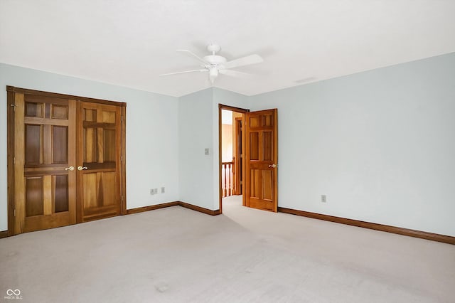 unfurnished bedroom featuring light colored carpet, ceiling fan, and a closet