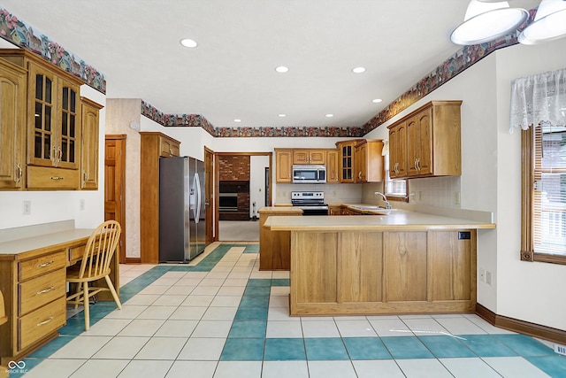 kitchen featuring a breakfast bar area, light tile patterned floors, stainless steel appliances, sink, and kitchen peninsula